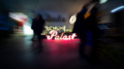 Buchstabenmuseum, Menschen laufen an der Beschriftung Schuhe Palast vorbei